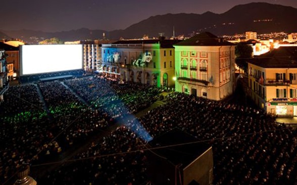 夜幕下的洛迦诺大广场上，数以千计的观众在观看露天电影。