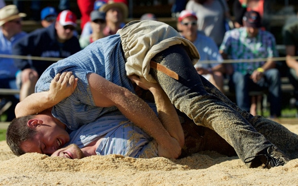 Dos luchadores suizos durante el combate en la arena de serrín.