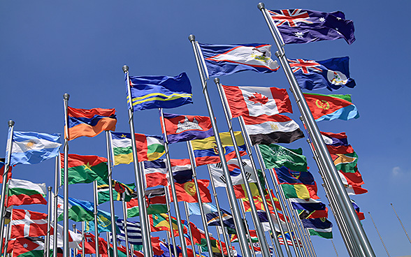 Zahlreiche Masten mit Flaggen diverser Länder.