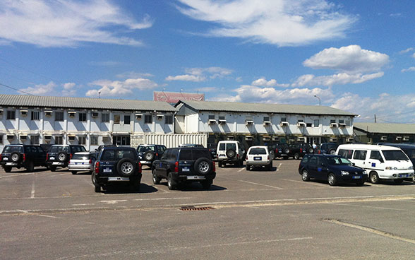 Cars in a car park in front of an office complex in Pristina.