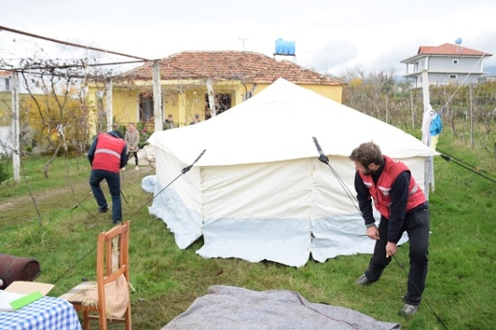 Swiss humanitarian team setting up a tent in a Kurbin village, December 3d, 2019