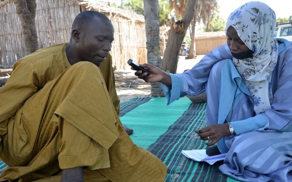 An RNI journalist talks to a listener during a report from Bol, in the Lac province.