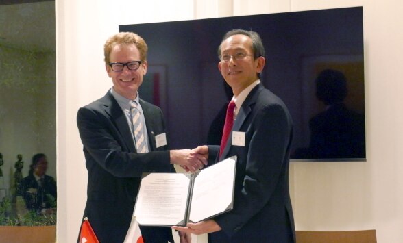 覚書締結後に握手するシュワルツェネッガー教授(左)と喜連川所長(右)©在日スイス大使館