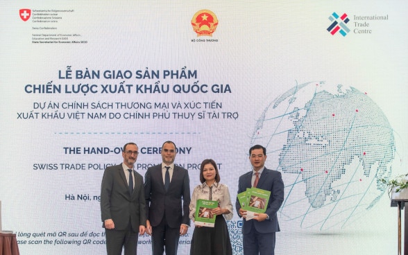 Mr. Werner Gruber, head of Swiss Cooperation Office in Vietnam (on the left) hands over the export development implementation strategies for five priority sectors to the representative of the Ministry of Industry and Trade