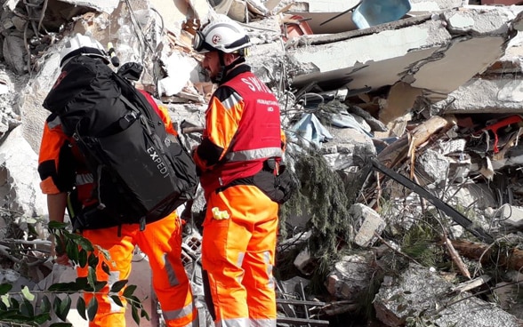 Due uomini di fronte a un edificio distrutto. 