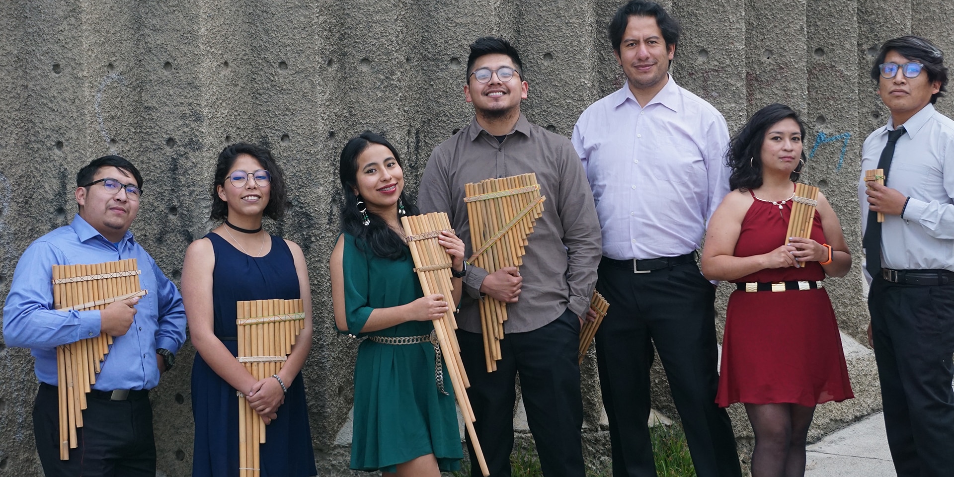 I sette musicisti e il compositore dell’Ensemble OEIN sono in piedi. In mano, alcuni flauti di pan. 