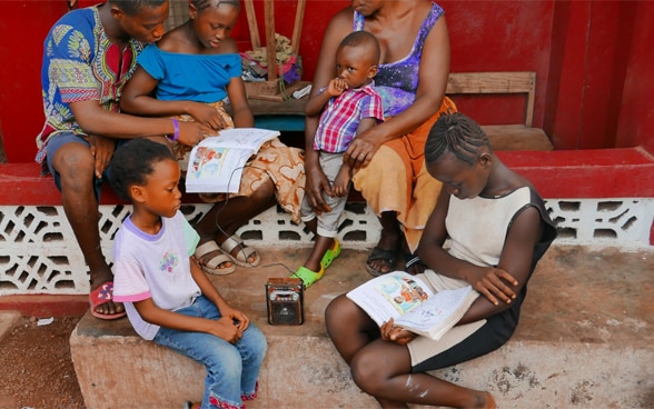 Eine Familie in Kambia Sierra Leone beim Heimunterricht.