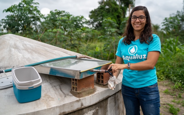 Anna Luisa Beserra, jeune entrepreneuse brésilienne, posant près d’un réservoir d’eau.