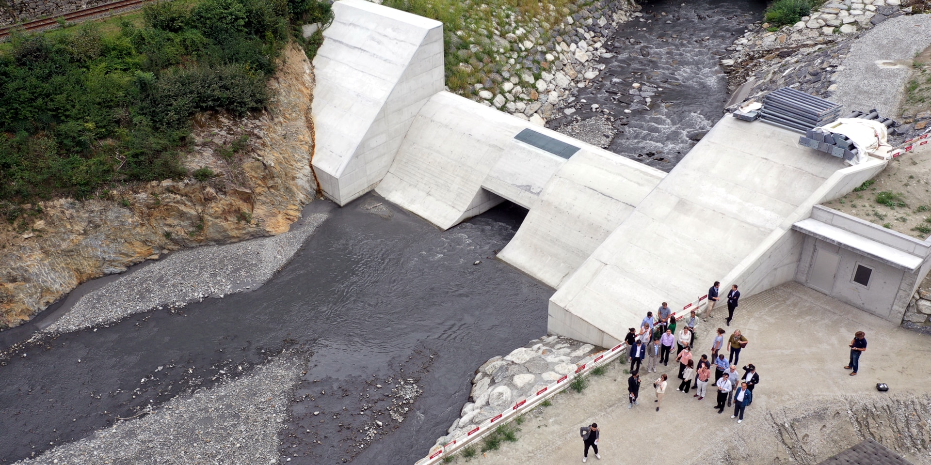 Aerial view of the South East Asian delegations standing near a dam.