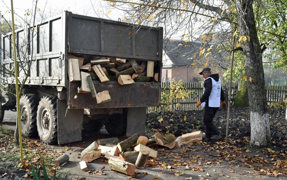 Un homme est debout à côté d’un camion.