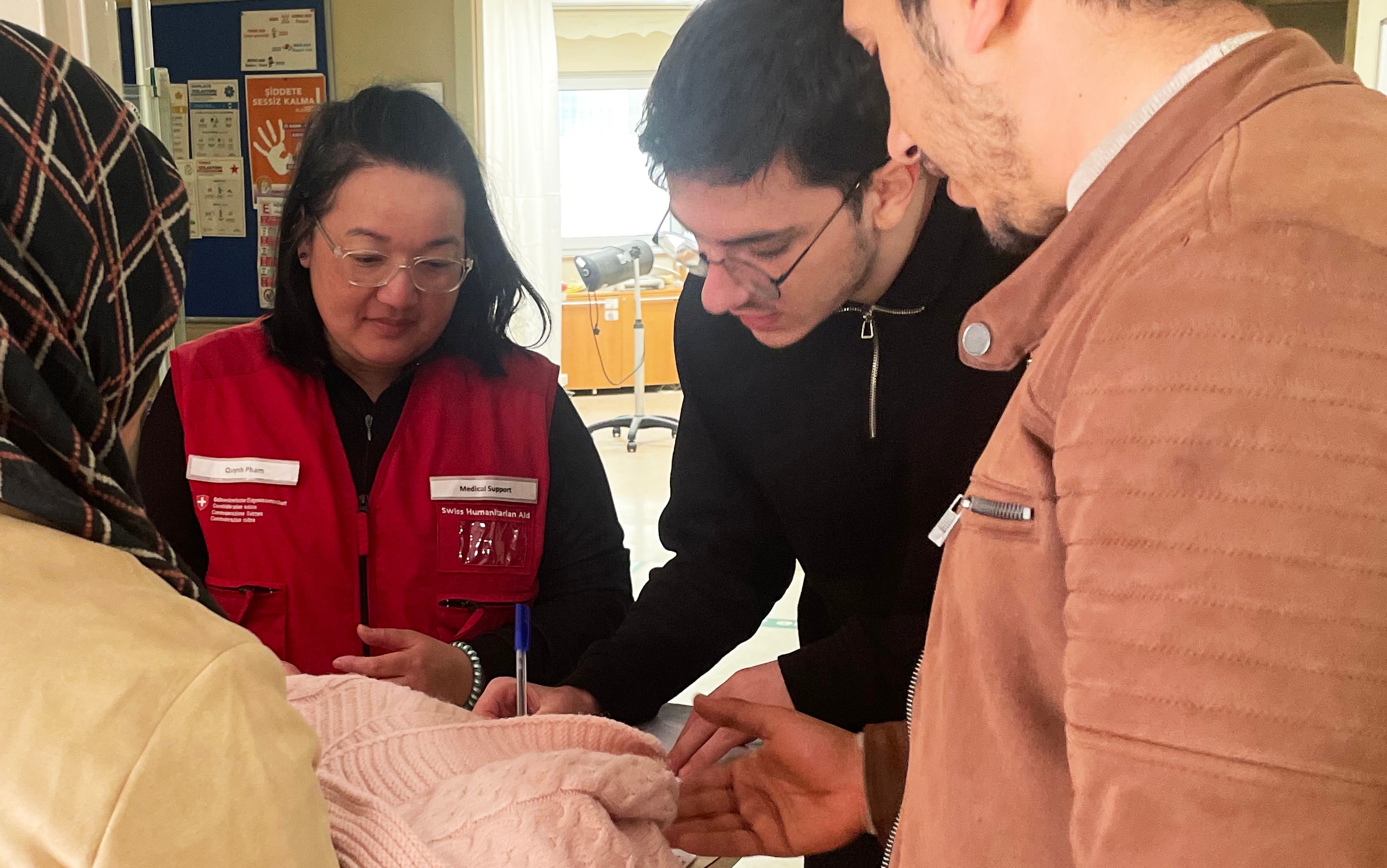 Eine Krankenpflegerin des SKH macht zusammen mit einem Übersetzer und Medizinstudent die erste Triage der Patienten.