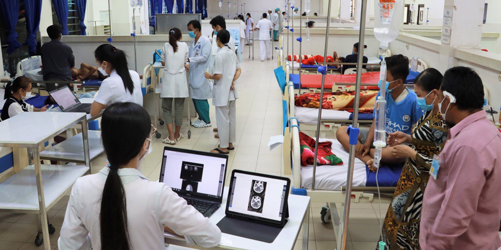 Vista interior de una habitación compartida en un hospital infantil Kantha Bopha con pacientes y personal cuidador.