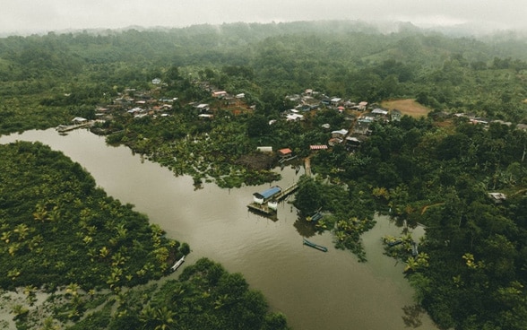 Un villaggio nella Colombia sud-occidentale circondato da una giungla lussureggiante e da un fiume.