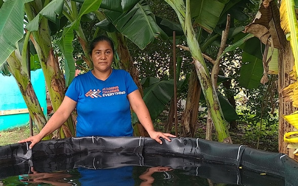 Una campesina nicaragüense delante de su depósito de agua.