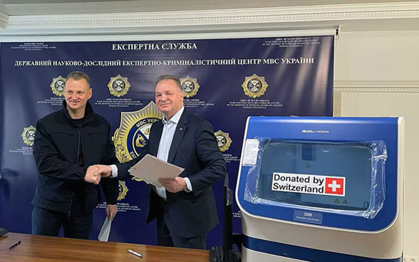 Claude Wild, ehemaliger Botschafter in der Ukraine, übergibt dem «State Forensic Scientific Research Center» in Kiew Material für die Durchführung von DNA-Analysen.