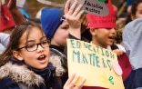 Page de titre du Rapport mondial de suivi de l’éducation. Plusieurs enfants brandissent des pancartes en lien avec l’importance de l’éducation