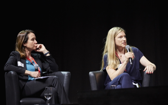 Davorka Shepherd et Andrea Heinzer sont assises sur la scène. Andrea Heinzer parle dans son microphone. 