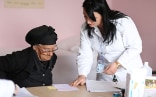 An elderly woman receives prescription in a health care facility in Albania.