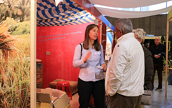 All'OLMA 2015 una collaboratrice della DSC parla con un visitatore.