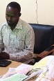 Assis à son bureau, un employé communal de la municipalité de Hargeisa entre les données de factures payées dans un système informatique.