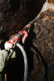 A miner drilling rock in search of gold.