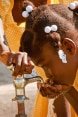Une jeune fille boit de l'eau du robinet