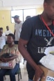 Alcuni cittadini haitiani ricevono cartoni contenenti articoli igienici.