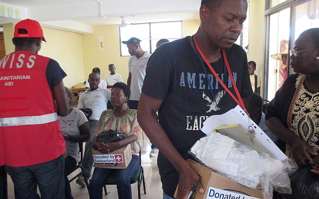 Alcuni cittadini haitiani ricevono cartoni contenenti articoli igienici.