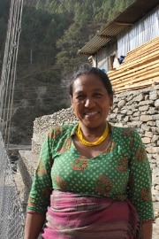 Sanu Maya Tamang in piedi vicino al ponte.