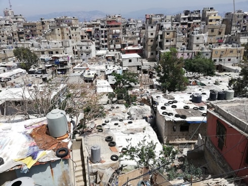 aerial view of the school in Hay el Gharbé with water tanks and tyres on the roofs of the houses.
