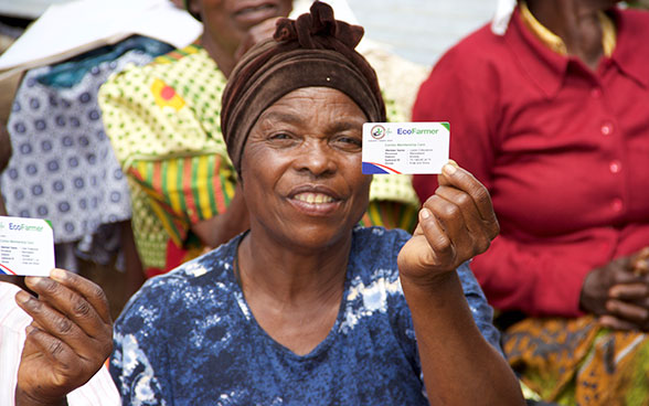 Eine Bäuerin zeigt ihren Eco-Farmer-Ausweis.