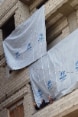 Two women wearing veils on a balcony in a building draped with UNHCR flags. 