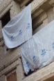 Two women wearing veils on a balcony in a building draped with UNHCR flags.