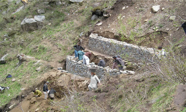 Pour limiter les risques de glissements de terrain, des habitants de la vallée de Chail érigent des murs de pierre sèche sur des talus.