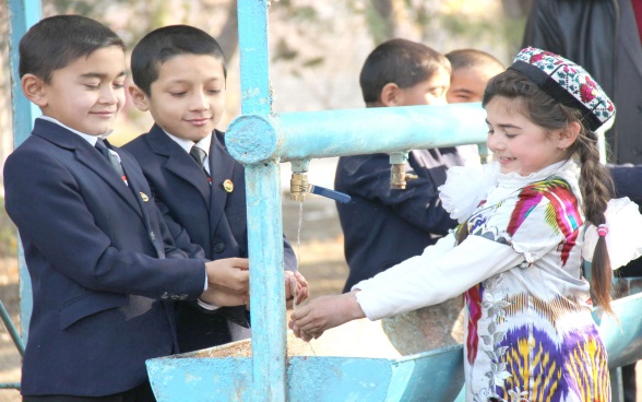 Three children around a fountain.