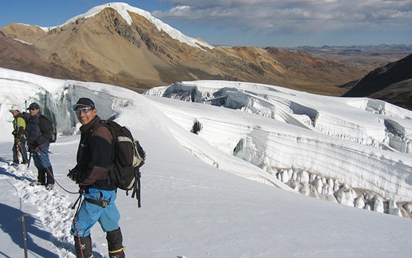 Menschen auf einem Berg der Kette Vilcanota in Peru.