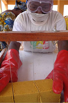 Un apprenti apprend à découper des blocs de savon 