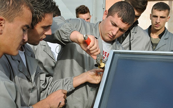 Aprendices albaneses trabajan en una máquina termohidráulica