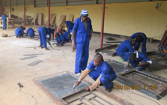 Apprendisti saldatori al lavoro sotto la supervisione di un istruttore. 