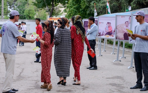 Le giovani donne ricevono opuscoli informativi in un'area pedonale.