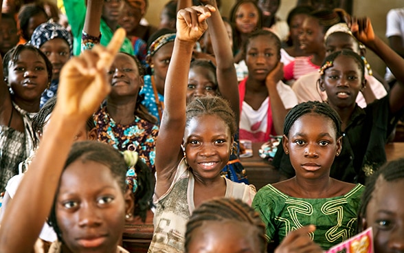 African girls raising their hands.