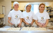 Three young women apprentices working in a bakery.