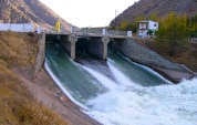 Torrents of water gush through the sluice gates of a dam.