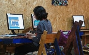 A woman sitting at a computer works with the UN CC:Learn platform.