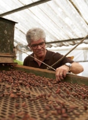 Anton von Weissenfluh devant une bande transporteuse de fèves de cacao 