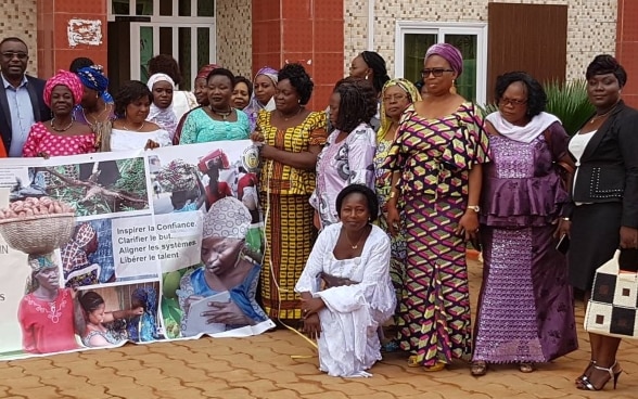 Foto di gruppo di alcune consigliere comunali e municipali del Benin, la maggior parte in abiti tradizionali, che posano con uno striscione.