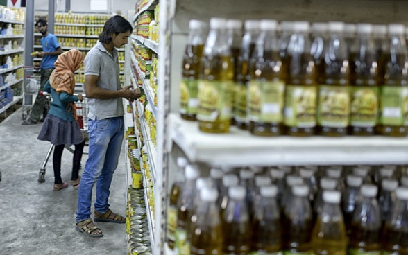 Des jeunes gens achètent des denrées alimentaires dans un supermarché.