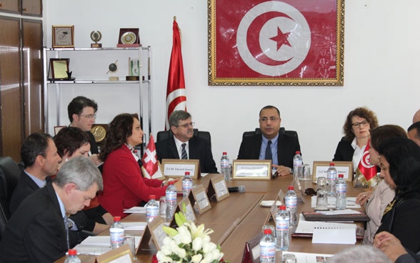 Des Tunisiens se concertent autour d'une table.
