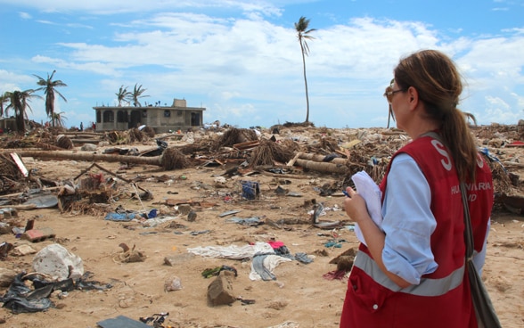Eine Frau der humanitären Hilfe aus der Schweiz betrachtet das vom Erdbeben verwüstete 