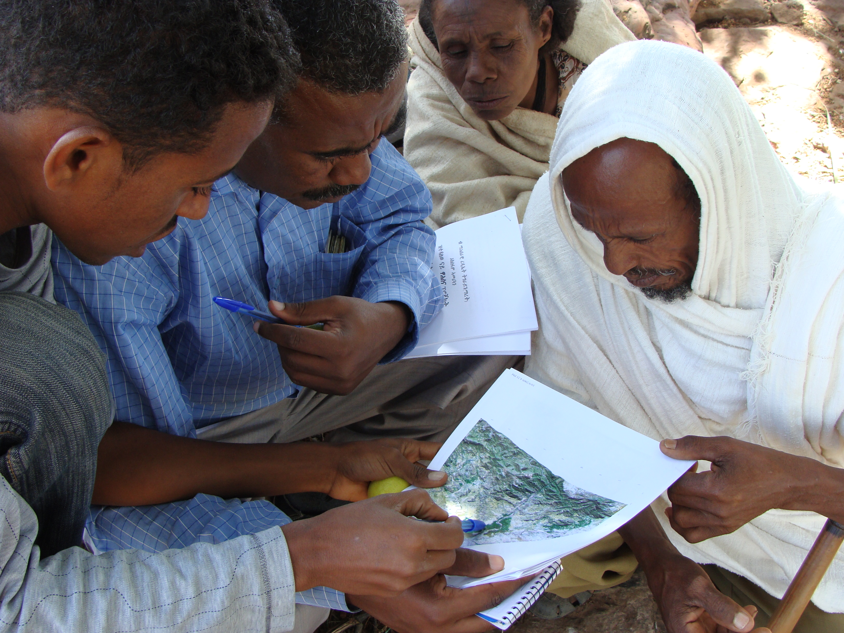 Unos campesinos descifran unos mapas de la vegetación